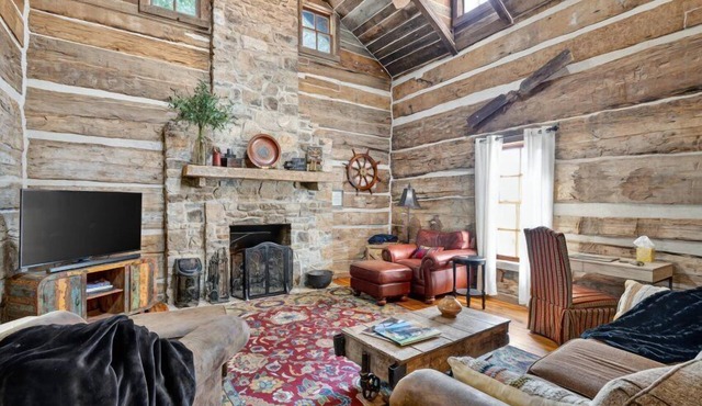 Historic lakefront log cabin on Lake Guntersville, restored from two pre-Civil War cabins. Sleeps 20 with 4BR/5BA, loft bunks, designer finishes, modern comforts, and steps to swimming, fishing & boating.
